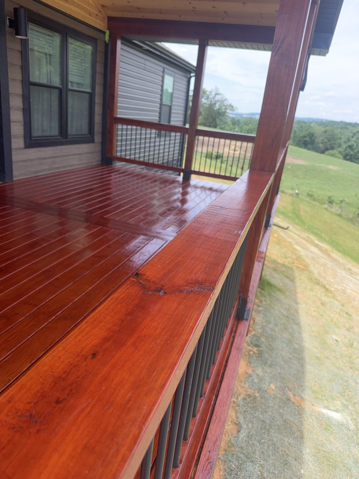 Top rail and black metal balusters on a PPG ProLuxe Mahogany stained deck near Johnson City TN