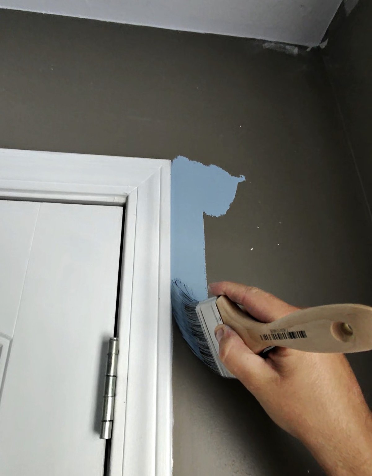 Purdy Spirex 3 inch brush cutting in Emerald Symmetry blue paint above a white door frame