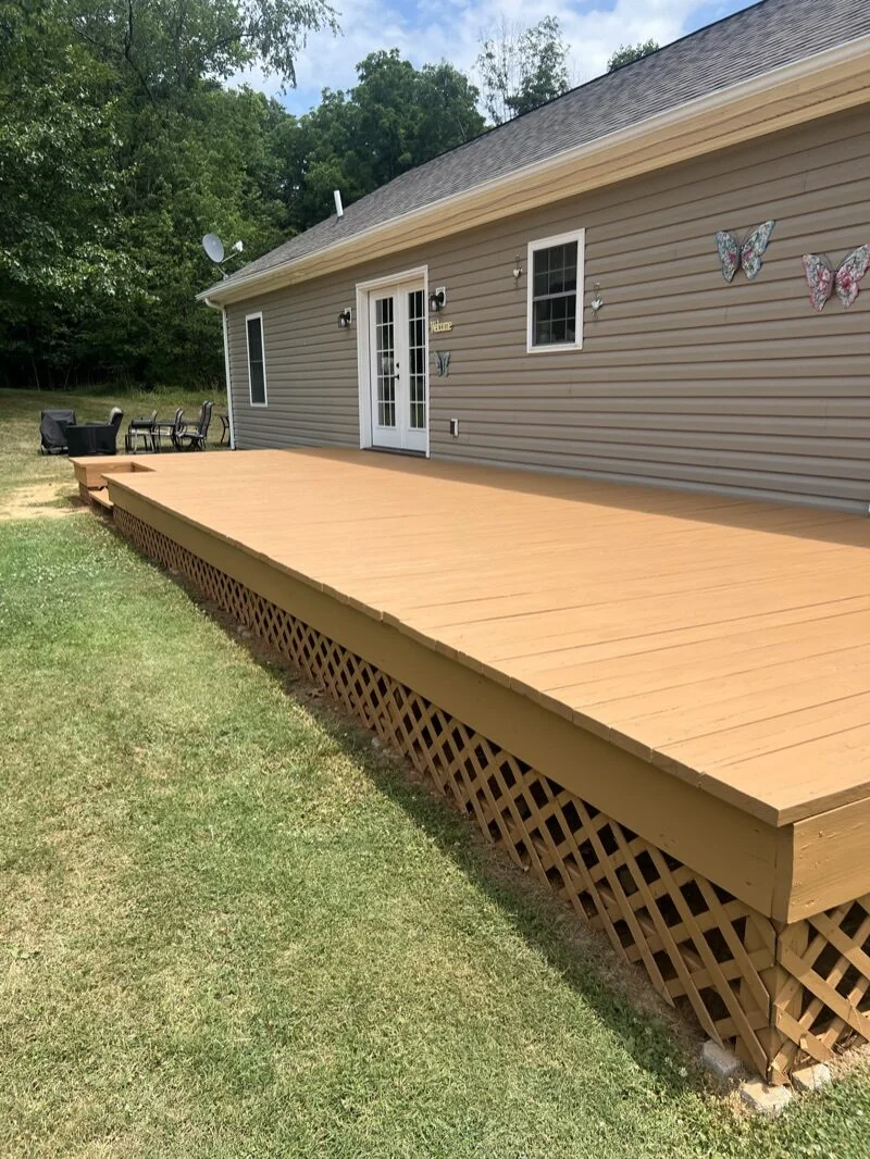 Tan house exterior with freshly stained lattice and deck